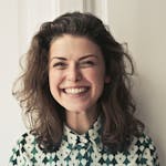 Portrait of a joyful brunette woman with a vibrant smile indoors, capturing happiness and positivity.